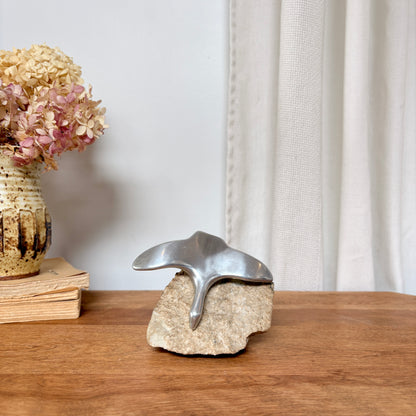 Oiseau en aluminium sur pierre