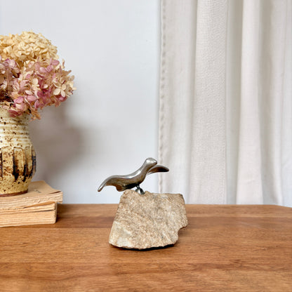 Oiseau en aluminium sur pierre
